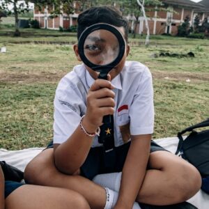 a boy looking through magnifying glass